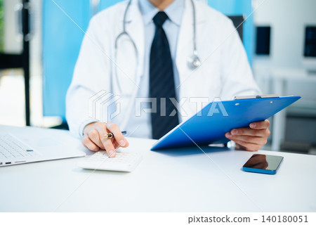 Healthcare costs and fees concept.Hand of smart doctor used a calculator and smartphone, tablet for medical costs at hospital Healthcare costs and fees concept.Hand of smart doctor used a calculator and smartphone, tablet for medical costs at hospital 140180051