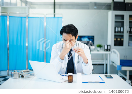 Asian doctors look stressed while reviewing patient results on laptops in a modern hospital clinic. Concept of medical pressure, diagnosis, and healthcare Asian doctors look stressed while reviewing patient results on laptops in a modern hospital clinic. Concept of medical pressure, diagnosis, and healthcare 140180073
