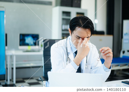 Asian doctors look stressed while reviewing patient results on laptops in a modern hospital clinic. Concept of medical pressure, diagnosis, and healthcare Asian doctors look stressed while reviewing patient results on laptops in a modern hospital clinic. Concept of medical pressure, diagnosis, and healthcare 140180110