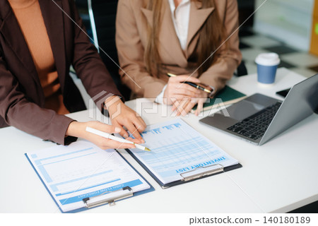The business team analyzes revenue charts and graphs with laptop and tablet.Business analysis The business team analyzes revenue charts and graphs with laptop and tablet.Business analysis 140180189