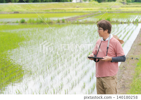 一名男子使用平板電腦管理他的農場。 一名男子使用平板電腦管理他的農場。 140180258
