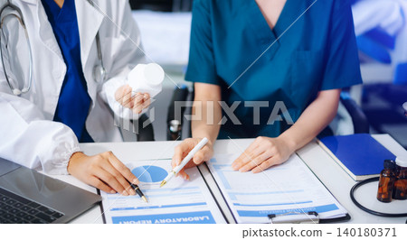 Medical team of doctors and a nurse using laptops in hospital office. Collaboration, diagnosis, and modern technology meet Medical team of doctors and a nurse using laptops in hospital office. Collaboration, diagnosis, and modern technology meet 140180371