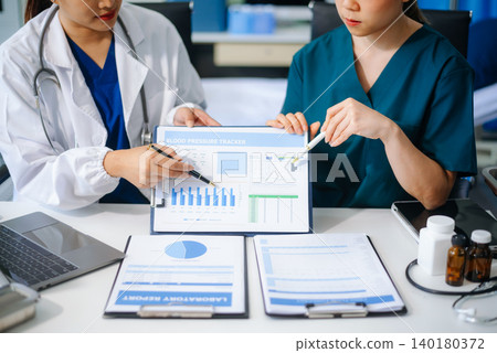 Medical team of doctors and a nurse using laptops in hospital office. Collaboration, diagnosis, and modern technology meet Medical team of doctors and a nurse using laptops in hospital office. Collaboration, diagnosis, and modern technology meet 140180372