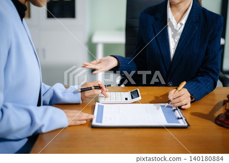 Business and lawyers discussing contract papers with brass scale on desk in office. Law, legal services, advice, justice and law concept 140180884