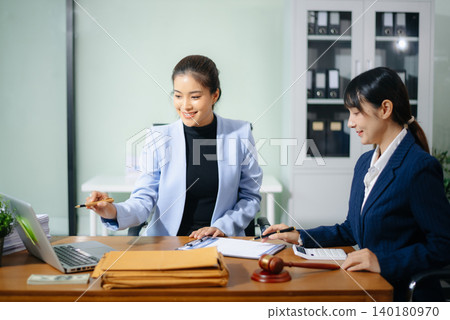 Professional female lawyers consulting on legal cases in a modern office. Perfect for law, business, justice Professional female lawyers consulting on legal cases in a modern office. Perfect for law, business, justice 140180970