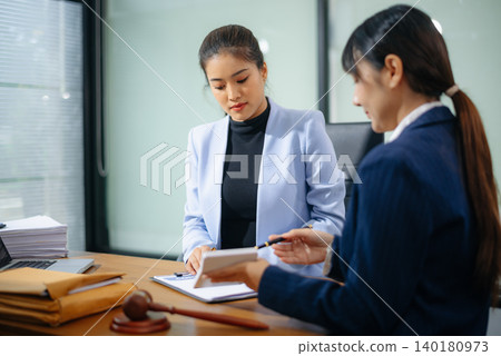 Professional female lawyers consulting on legal cases in a modern office. Perfect for law, business, justice Professional female lawyers consulting on legal cases in a modern office. Perfect for law, business, justice 140180973