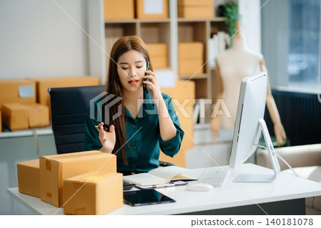 Asian woman prepares parcels and checks online orders on tablet and laptop for delivery online shopping Asian woman prepares parcels and checks online orders on tablet and laptop for delivery online shopping 140181078