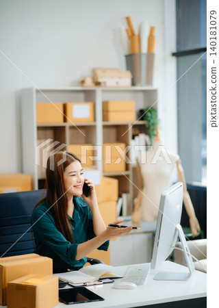Asian woman prepares parcels and checks online orders on tablet and laptop for delivery online shopping Asian woman prepares parcels and checks online orders on tablet and laptop for delivery online shopping 140181079