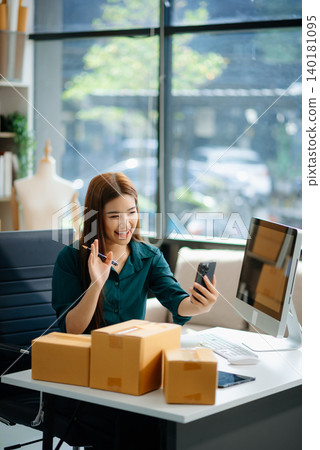 Asian woman prepares parcels and checks online orders on tablet and laptop for delivery online shopping Asian woman prepares parcels and checks online orders on tablet and laptop for delivery online shopping 140181095