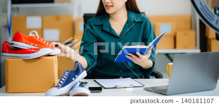 Businesswoman preparing product shipments. Highlighting creativity, entrepreneurship, and the small business journey Businesswoman preparing product shipments. Highlighting creativity, entrepreneurship, and the small business journey 140181107