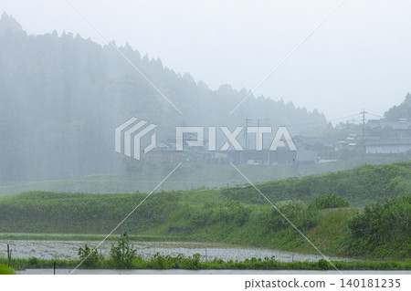 Heavy rain falling in the mountains: A beautiful natural landscape and houses amidst the downpour. Heavy rain falling in the mountains: A beautiful natural landscape and houses amidst the downpour. 140181235