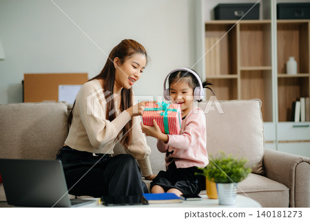 A caring mother and young daughter share a bonding moment doing homework at home. A caring mother and young daughter share a bonding moment doing homework at home. 140181273