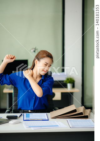 Overworked young Asian businesswoman office worker suffering from neck pain after had a long day Overworked young Asian businesswoman office worker suffering from neck pain after had a long day 140181353