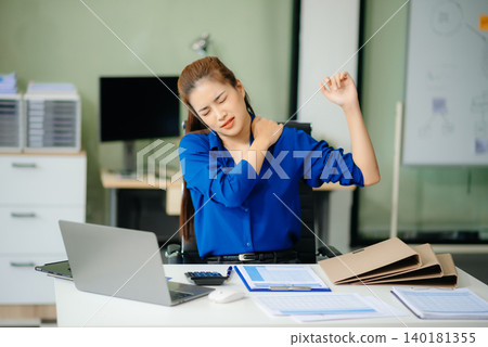 Overworked young Asian businesswoman office worker suffering from neck pain after had a long day Overworked young Asian businesswoman office worker suffering from neck pain after had a long day 140181355