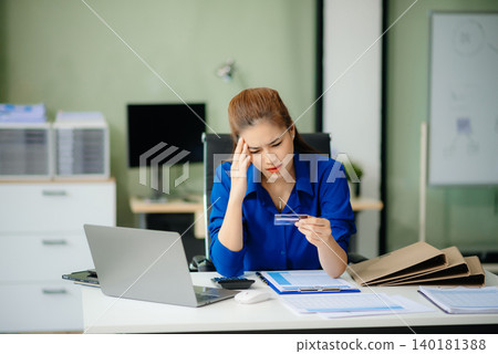 woman feeling migraine head strain.Overworked businesswoman financier while working on laptop and tablet woman feeling migraine head strain.Overworked businesswoman financier while working on laptop and tablet 140181388