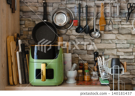 Kitchen counter with air fryer and cooking utensils in home kitchen during daylight Kitchen counter with air fryer and cooking utensils in home kitchen during daylight 140181437