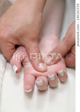 SPA salon and massage. Massage room. A massage therapist is working with a young woman. Hand massage. SPA salon and massage. Massage room. A massage therapist is working with a young woman. Hand massage. 140181559