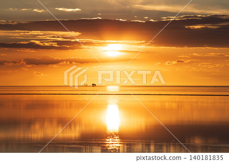 Serene sunset reflection over vast salt flat in Uyuni Bolivia 140181835