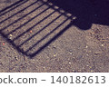 Shadows of playground equipment cast on the ground 140182613