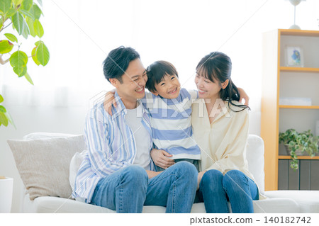 Family portrait of a family sitting on a sofa Family portrait of a family sitting on a sofa 140182742