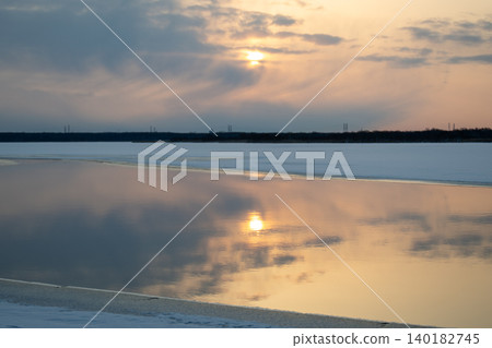 A morning at Lake Utonai, bathed in rays of sunlight. The frozen lake surface and its reflection create a beautiful winter landscape. A morning at Lake Utonai, bathed in rays of sunlight. The frozen lake surface and its reflection create a beautiful winter landscape. 140182745