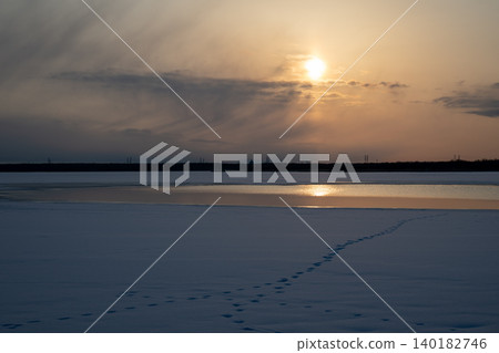 A morning at Lake Utonai, bathed in rays of sunlight. The frozen lake surface and its reflection create a beautiful winter landscape. A morning at Lake Utonai, bathed in rays of sunlight. The frozen lake surface and its reflection create a beautiful winter landscape. 140182746