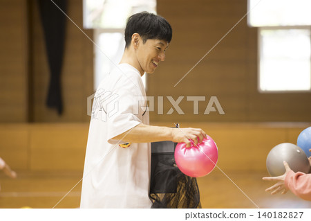 一名男性體育教練正在為球類訓練做準備。 140182827