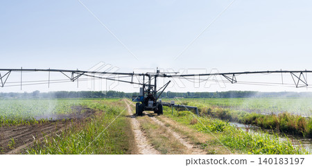 Autonomous machine is moving watering pivot along irrigation canal. Autonomous machine is moving watering pivot along irrigation canal. 140183197