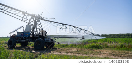 Autonomous machine is moving watering pivot along irrigation canal. 140183198