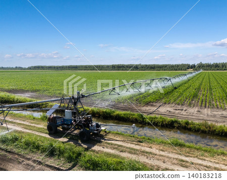 Autonomous machine is moving watering pivot along irrigation canal Autonomous machine is moving watering pivot along irrigation canal 140183218