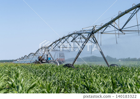 Autonomous machine is moving watering pivot along irrigation canal. 140183322