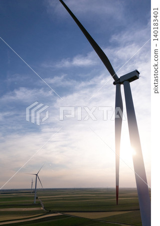 Aerial view of wind turbine on an agricultural filed at sunset. Close up of blades. 140183401