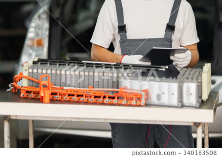 Serviceman repairs electric battery pack of hybrid car Serviceman repairs electric battery pack of hybrid car 140183508