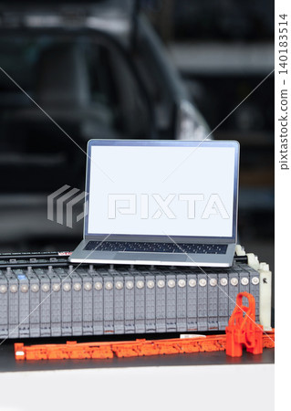 Serviceman repairs electric battery pack of hybrid car using laptop Serviceman repairs electric battery pack of hybrid car using laptop 140183514
