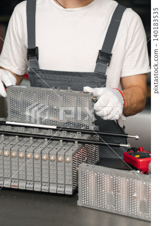 Serviceman repairs electric battery pack of hybrid car Serviceman repairs electric battery pack of hybrid car 140183535