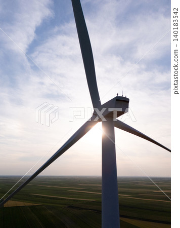 Aerial view of wind turbine on an agricultural filed at sunset. Close up of blades. Aerial view of wind turbine on an agricultural filed at sunset. Close up of blades. 140183542