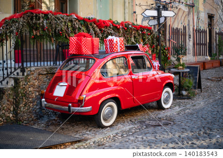Old retro red car as a christmas decoration on a city street Old retro red car as a christmas decoration on a city street 140183543