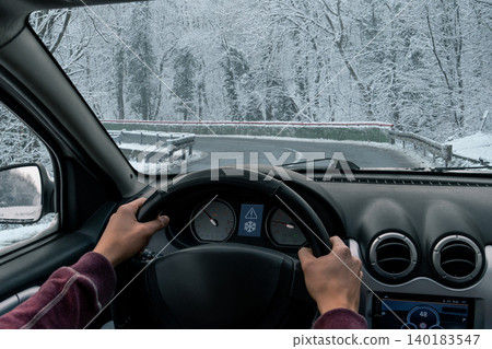 A man drives a car on a winter road in a blizzard. A man drives a car on a winter road in a blizzard. 140183547