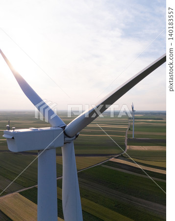 Aerial view of wind turbine on an agricultural filed at sunset. Close up of blades. Aerial view of wind turbine on an agricultural filed at sunset. Close up of blades. 140183557