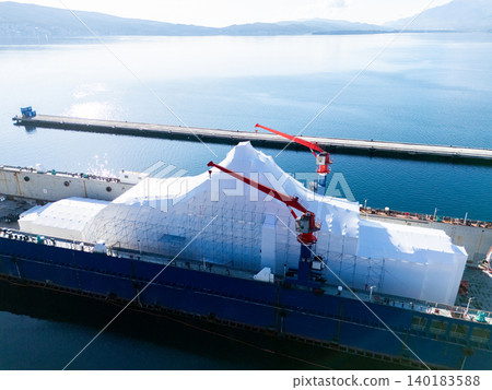 Aerial view of a luxury yacht refit, repair, service and maintenance in a floating dock at a marina 140183588