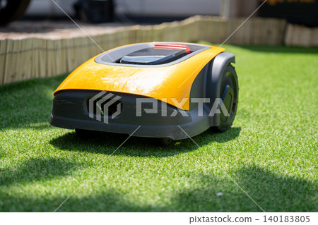 Autonomous robot lawnmower on a green lawn Autonomous robot lawnmower on a green lawn 140183805