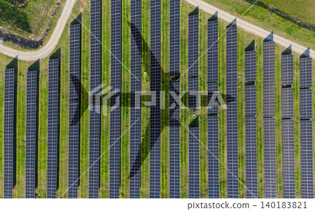 Aerial view of an airplane shadow cast across a solar panel field. Aerial view of an airplane shadow cast across a solar panel field. 140183821