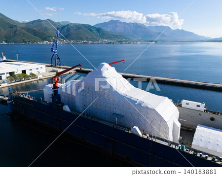 Aerial view of a luxury yacht refit, repair, service and maintenance in a floating dock at a marina. 140183881