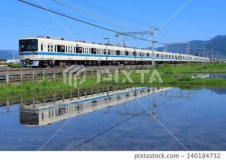 Odakyu 8000 series train, set 8262F, reflected on the water's surface. Odakyu 8000 series train, set 8262F, reflected on the water's surface. 140184732