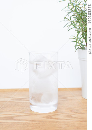 A glass of water and a houseplant A glass of water and a houseplant 140185278