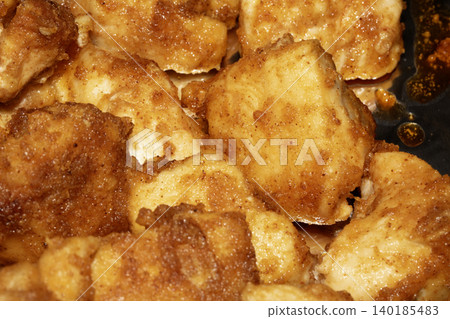 Well seasoned golden batter style chicken pieces fried and on some foil close up Well seasoned golden batter style chicken pieces fried and on some foil close up 140185483
