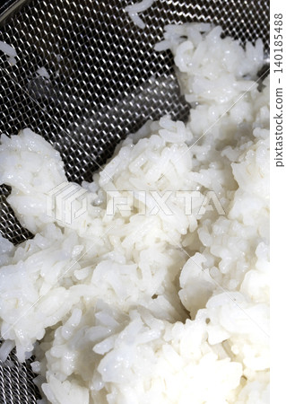 Close up of white rice cooked and in a sieve metal being drained to eat 140185488