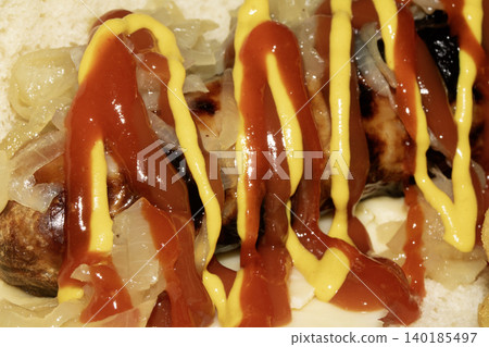Close up of a hot dog with ketchup and mustard squirted on top dressing Close up of a hot dog with ketchup and mustard squirted on top dressing 140185497