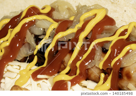 Close up of a hot dog with ketchup and mustard squirted on top dressing Close up of a hot dog with ketchup and mustard squirted on top dressing 140185498