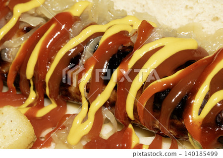 Close up of a hot dog with ketchup and mustard squirted on top dressing Close up of a hot dog with ketchup and mustard squirted on top dressing 140185499